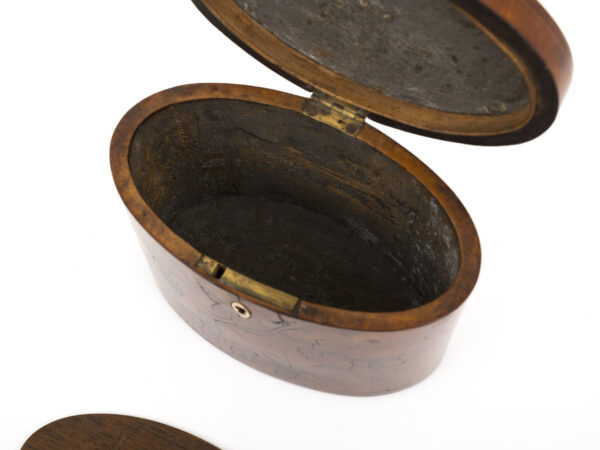 antique oval tea caddy open with lid out on a white background