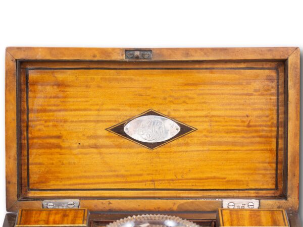 Close up of the oval silver initial plaque to the inside of the lid