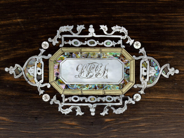 Close up of the intricate mother of pearl and abalone initial plaque