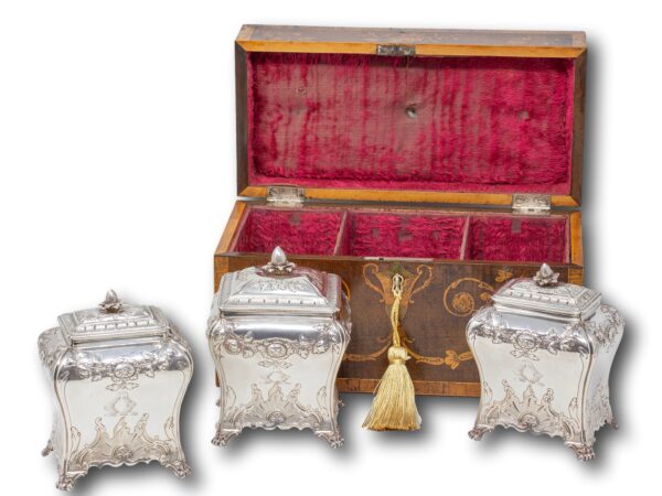 Overview of the George II Harewood Inlaid Tea Chest in a decorative demonstration with the caddies removed and key inserted