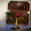 Overview of the painted tea caddy in a decorative collectors setting
