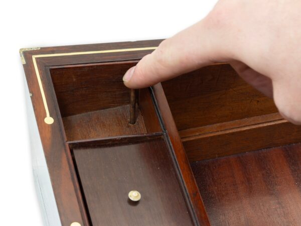 Close up of the right hand side inkwell compartment when removed showing the secret locking mechanism being pressed by the brass pin