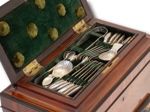 Close up of the secret compartment housing a selection of silver spoons